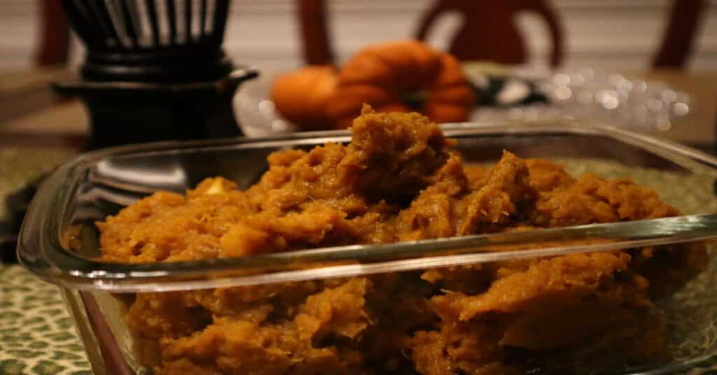 Curry Pumkin in dish on dining table with pumpkins and chair and other table décor in the background