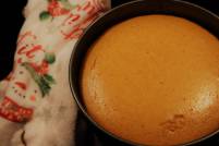 Pumpkin cheesecake in a springform pan next to a Christmas towel