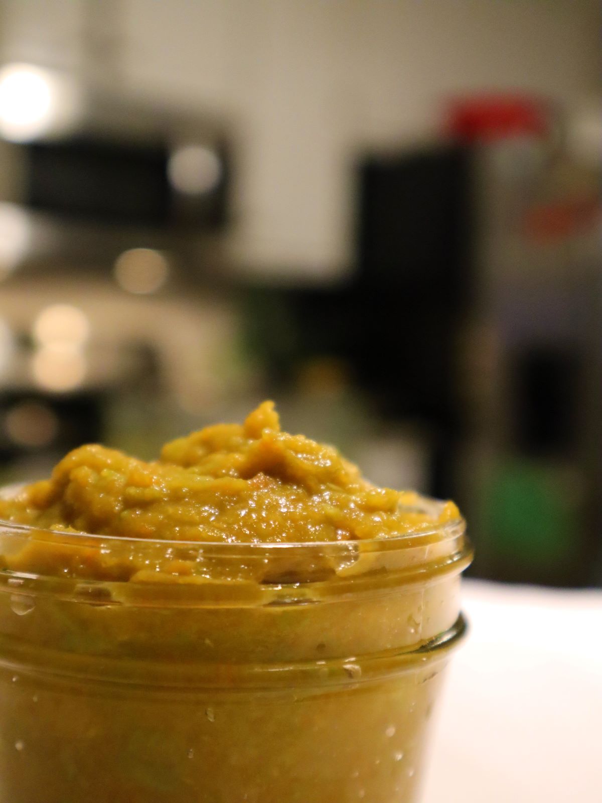 Baby food in a small mason jar on a kitchen counter top