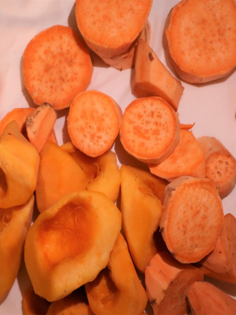 Sweet potatoes and mini pumpkins in large pieces on a white background