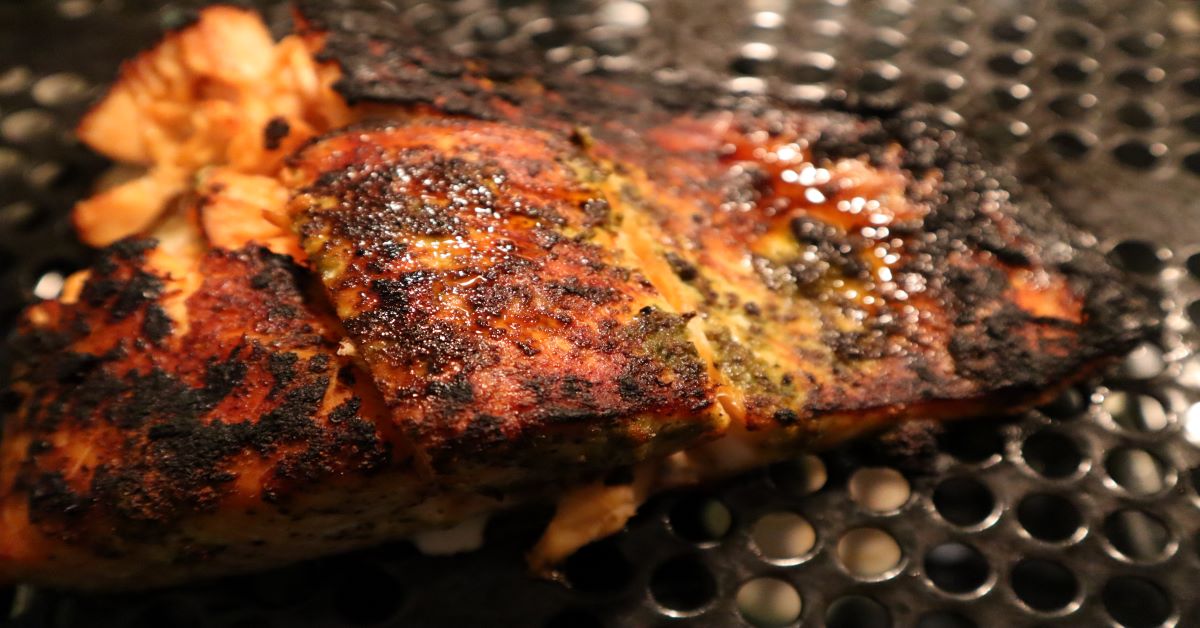 Blackened Salmon cooked in broiler setting on a black grated tray