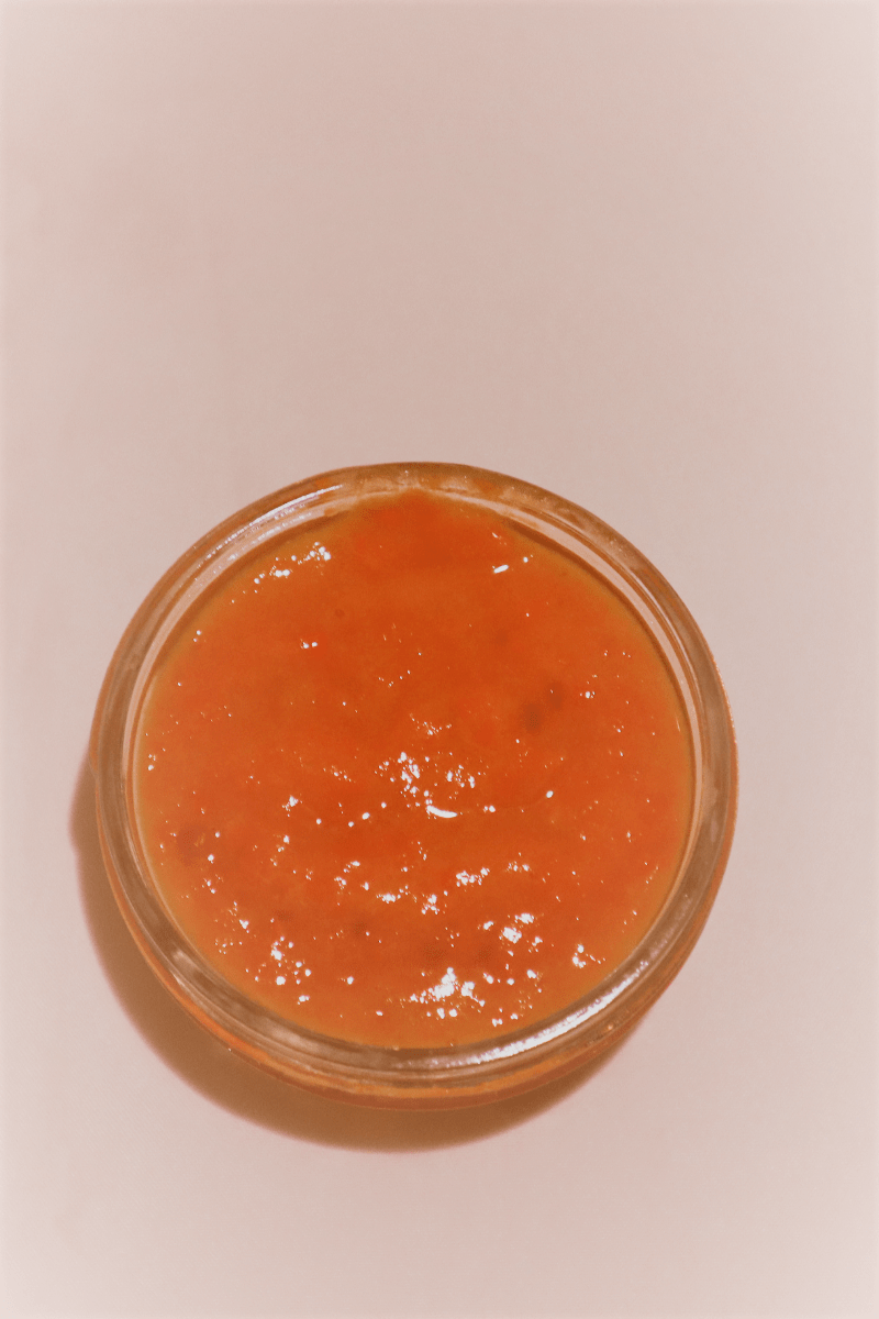 Banana, Carrot, Mango Homemade Baby Food Recipe on a white background. Overhead view of portion in small ramekin. Orange color.