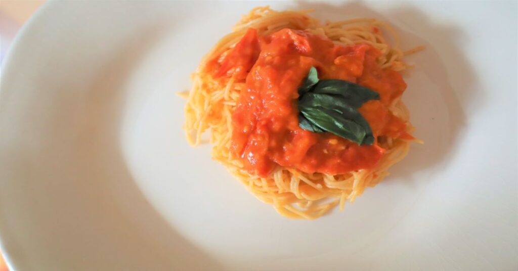 Angel Hair Pasta With Homemade Tomato Sauce topped with fresh basil