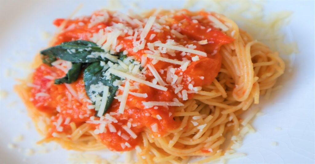 Angel Hair Pasta With Homemade Tomato Sauce topped with fresh basil