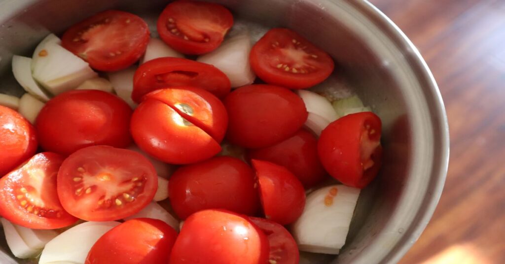 Pot filled with halved Campari tomatoes and onions