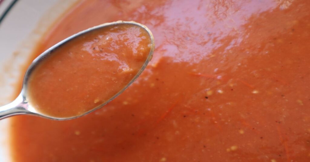 bowl of homemade vegan tomato soup (close up with spoon)