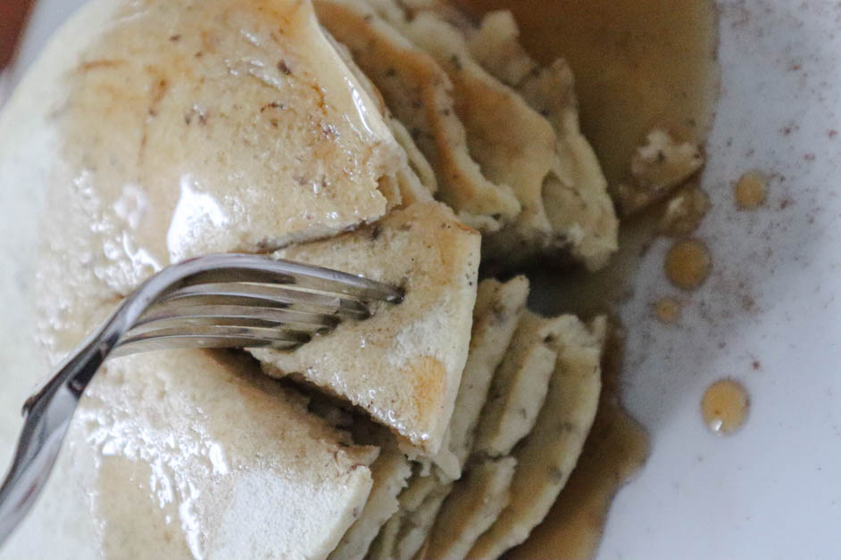 Stack of pancakes with one "bite" cut thru the entire stack with fork in that bite