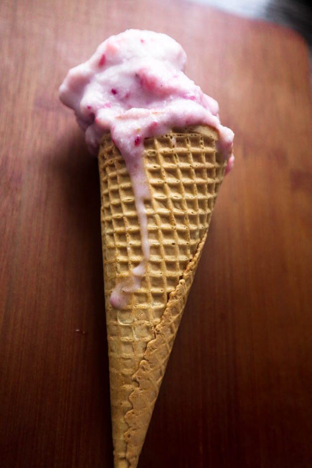 Strawberry Ice Cream in a Waffle Cone on Brown wooden background