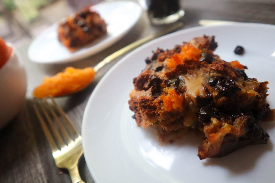 Chocolate orange bread pudding in two separate white plates with a spoon of orange marmalade between them